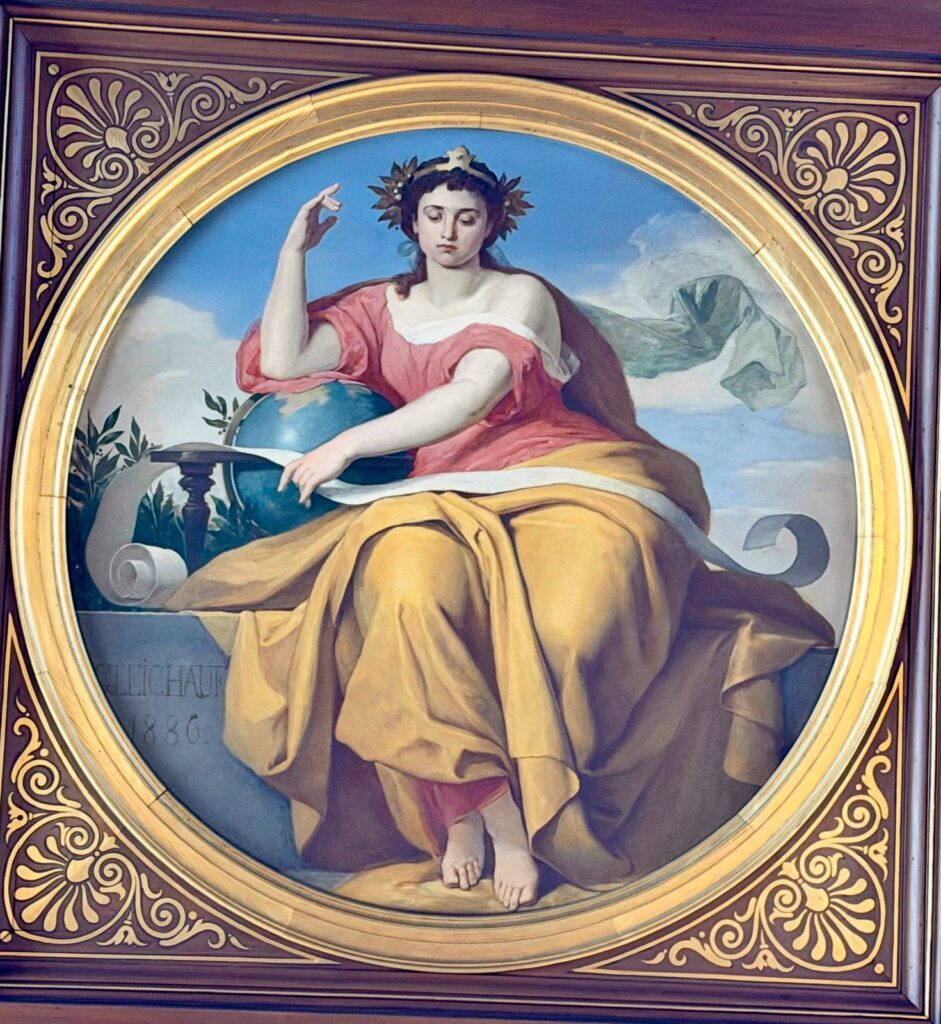 Frau auf Globus mit Schriftrolle und gelbem Gewand Allegorische Darstellung der Fakultät für Philosophie. Weibliche Sitzfigur mit den charakteristischen Attributen Schriftrolle und Globus. Teil eines Ensembles der vier Gründungsfakultäten der Universität Heidelberg in der Aula der Alten Universität in Heidelberg