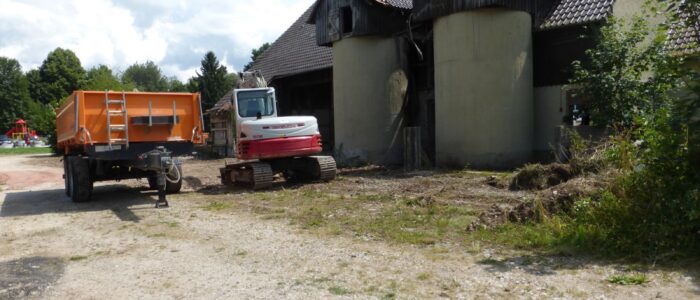 vor den alten Silos steht der Bagger. Im Hintergrund sieht man den Schari