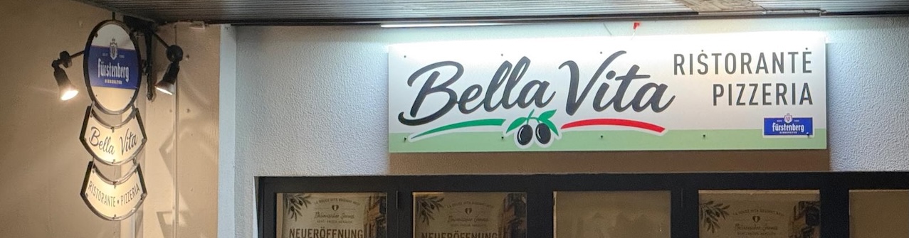 Bild vom Schild mit Bella Vita Ristorante Pizzeria bei Nacht angestrahlt