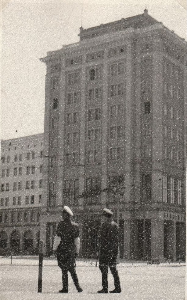 unschafes altes Foto mit Gebäude und zwei Männer in Uniform